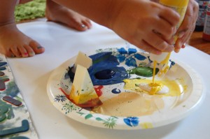 child squeezing paint