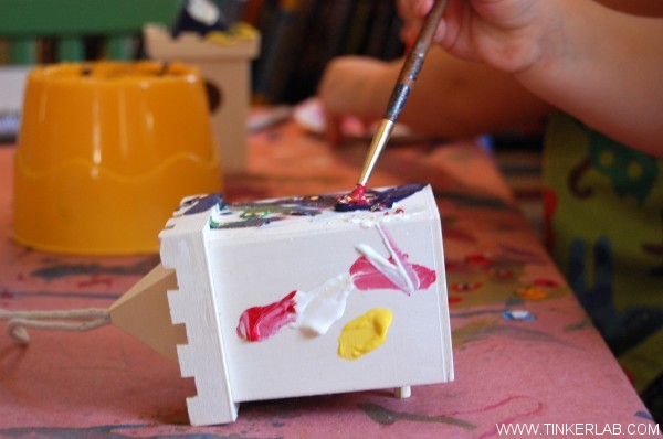 toddler painting birdhouse